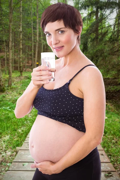 Donna incinta che beve bicchiere d'acqua — Foto Stock