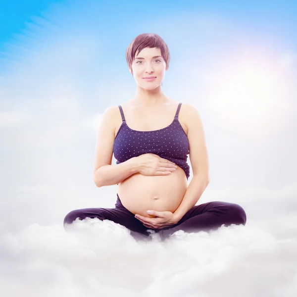 Woman sitting on exercise mat — Stock Photo, Image