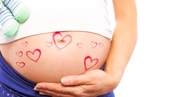 Pregnant woman holding baby shoes — Stock Photo, Image