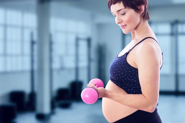 Pregnant woman lifting dumbbell Royalty Free Stock Photos