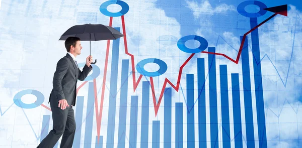 Businessman sheltering under black umbrella — Stock Photo, Image