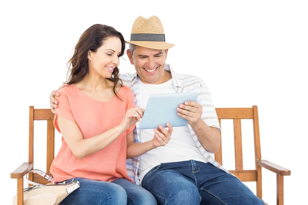 Pareja en banco usando tableta — Foto de Stock