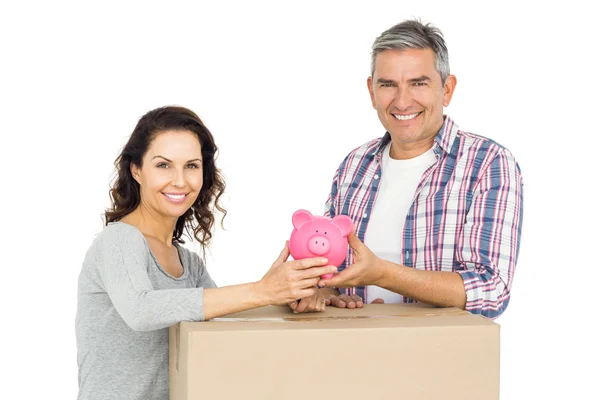 Casal com caixas e banco porquinho — Fotografia de Stock