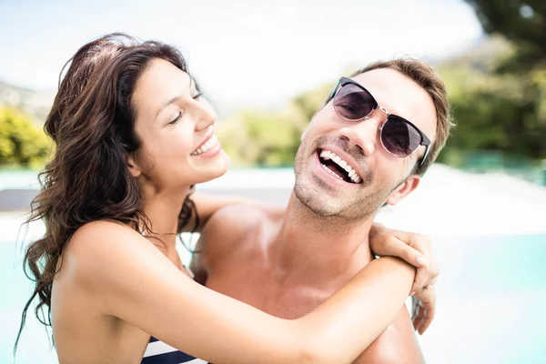 Couple cuddling each other near pool — Stock Photo, Image