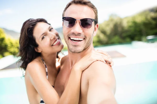 Пара улыбается возле бассейна — стоковое фото