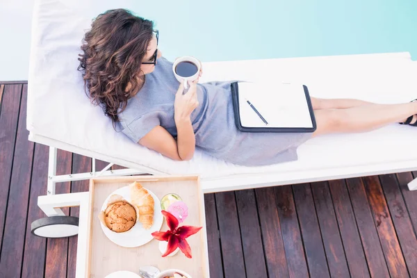 Vrouw met kopje thee in de buurt van het zwembad — Stockfoto