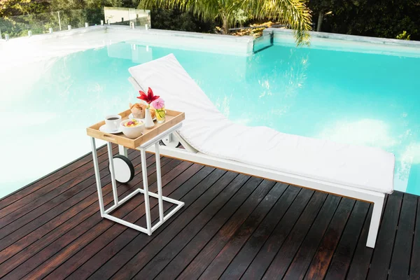 Tray with breakfast and sun lounger — Stock Photo, Image