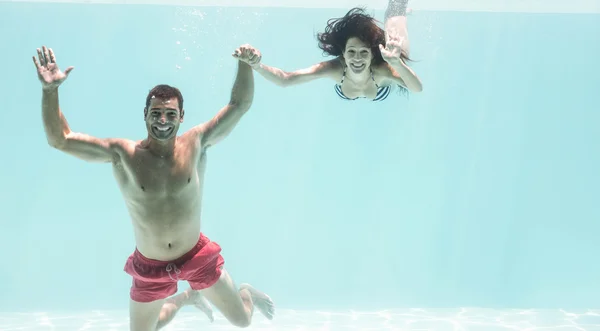 Pareja disfrutando bajo el agua en la piscina —  Fotos de Stock