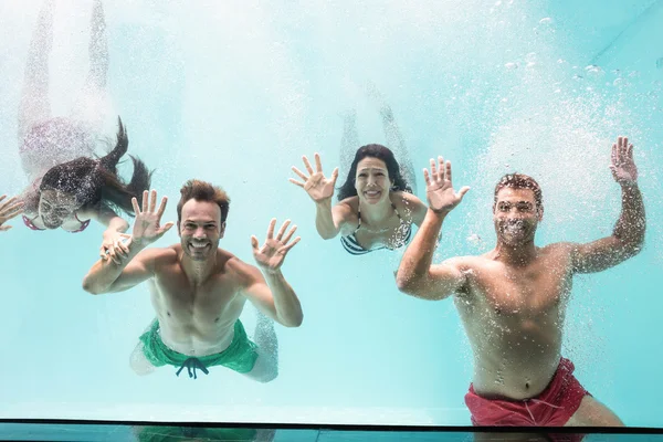 Parejas nadando bajo el agua en la piscina — Foto de Stock