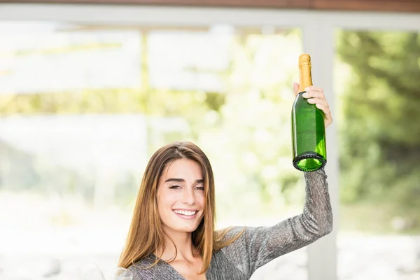 Kvinna anläggning champagne flaskan — Stockfoto