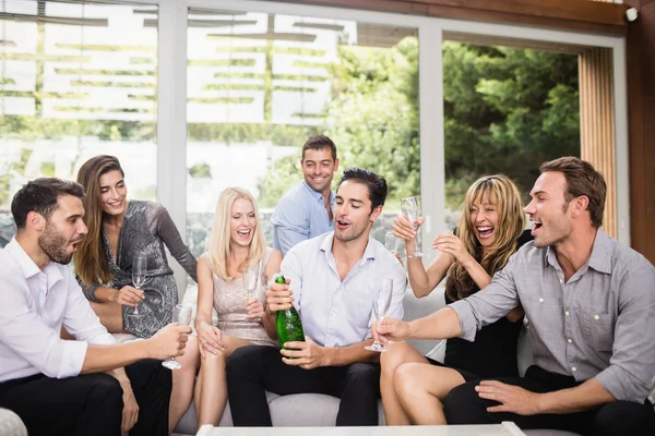 Mężczyzna popping butelek szampana z przyjaciółmi — Zdjęcie stockowe
