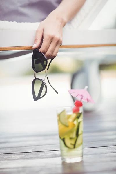 Womans hand holding sunglasses — Stock Photo, Image