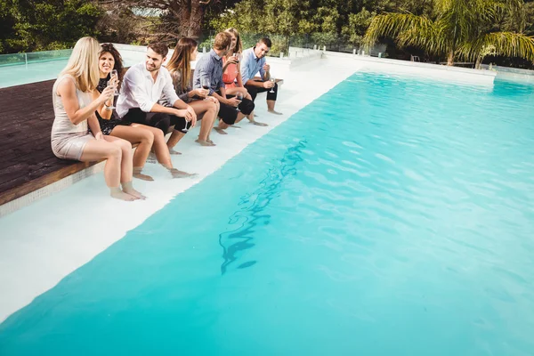 Junge Leute sitzen am Pool — Stockfoto