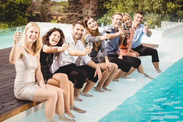 Jóvenes sentados junto a la piscina — Foto de Stock