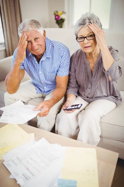 Senior paar met rekeningen op zoek bezorgd — Stockfoto