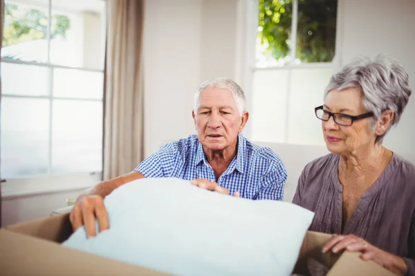 Senior couple unpacking cardboard box — Stock Photo, Image