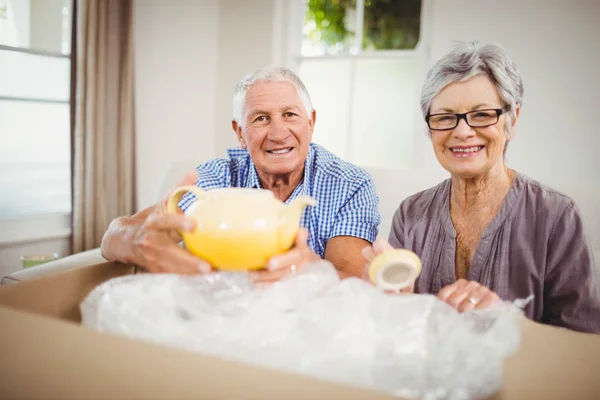 Casal sênior desembalagem caixa de papelão — Fotografia de Stock