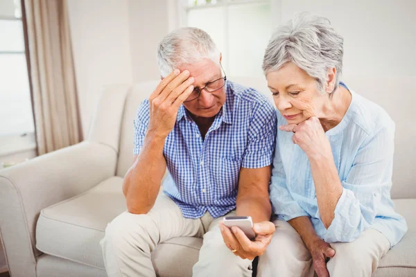 Trauriges Senioren-Paar schaut aufs Telefon — Stockfoto