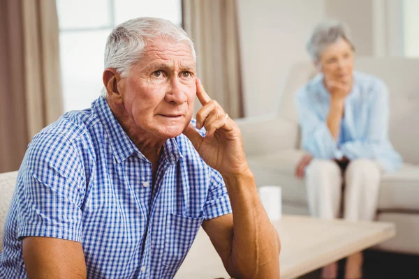Martwi się starszy człowiek siedzi na kanapie — Zdjęcie stockowe