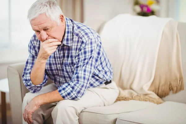 Oroliga äldre man sitter på soffan — Stockfoto