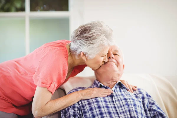Äldre kvinna kysser man på kinden — Stockfoto