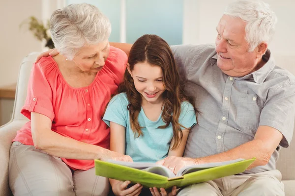 Grandparents reading book with granddaughter — Stock Photo, Image