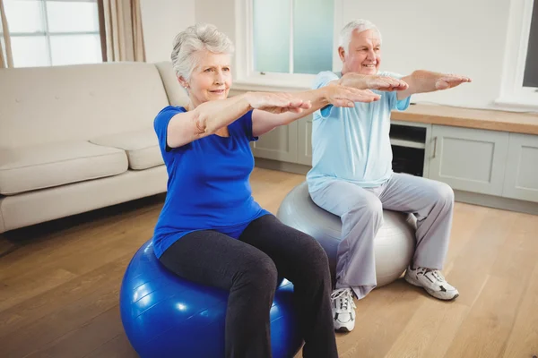 Senior couple exercising on exercise ball — Stock Photo, Image
