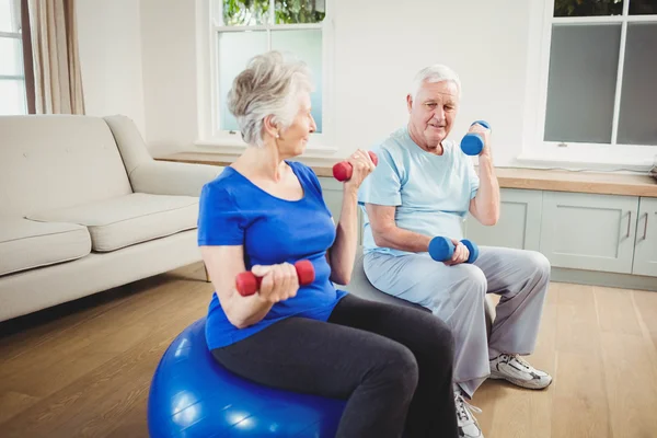 Senior couple lifting dumbbells — Stock Photo, Image