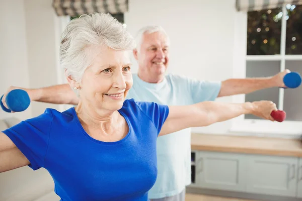 Casal sênior realizando exercício de alongamento — Fotografia de Stock