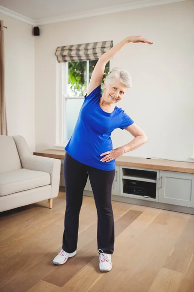 Äldre kvinna utför stretching motion — Stockfoto