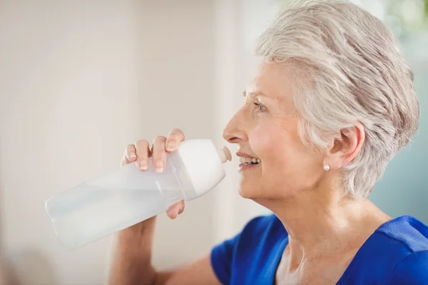 Счастливая пожилая женщина пьет воду — стоковое фото