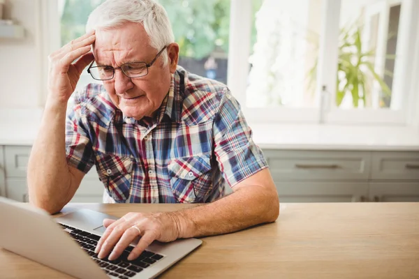 Bezorgd senior man met laptop — Stockfoto