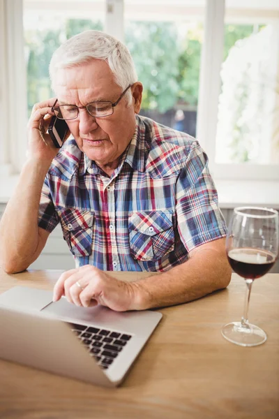 Besorgter Senior greift zum Telefon — Stockfoto