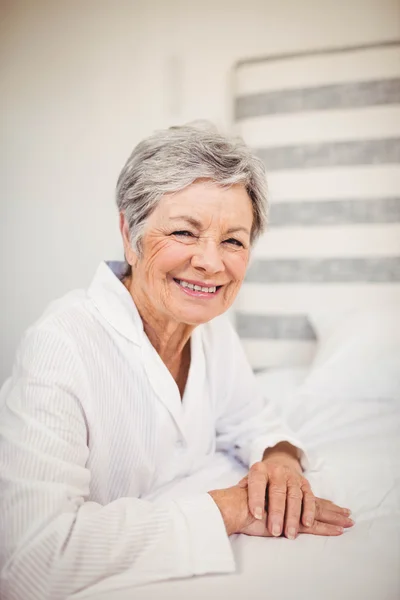 Seniorin sitzt auf Bett — Stockfoto