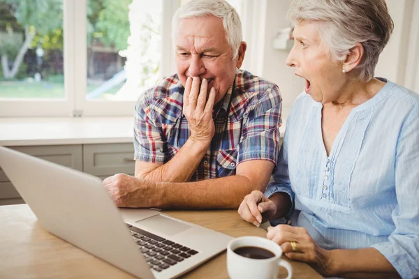 Verbaasd senior paar met behulp van laptop — Stockfoto