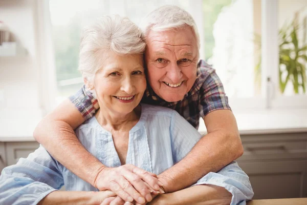Äldre par embracing hemma — Stockfoto