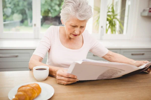 Senior kvinna läser tidningen — Stockfoto