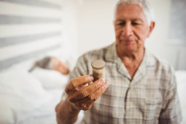 Senior mannen tittar på piller flaska — Stockfoto