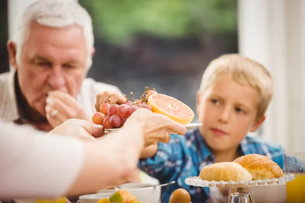 Händerna passerar plattan av frukter — Stockfoto