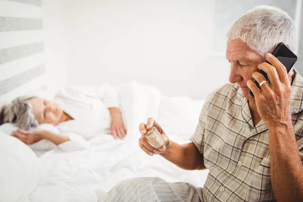 Hombre mayor mirando frasco de la píldora —  Fotos de Stock