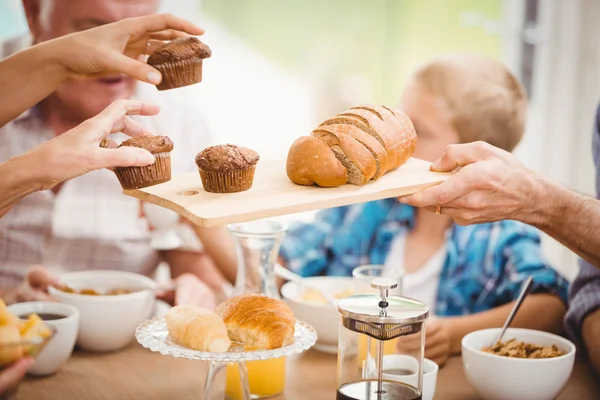 Händerna passerar cupcake och bröd — Stockfoto