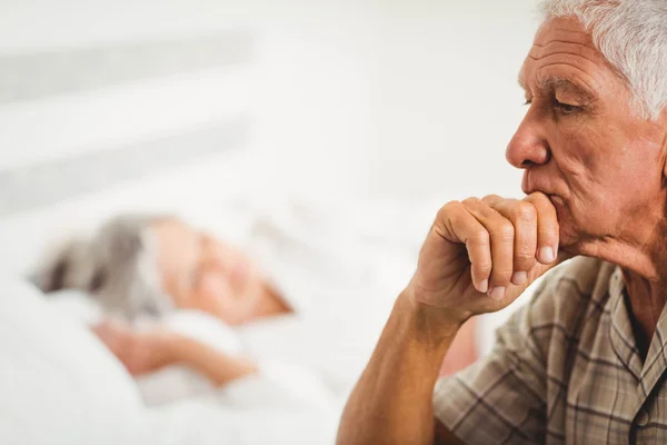 Preoccupato uomo anziano seduto sul letto — Foto Stock