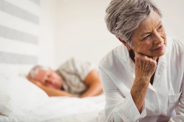 Femme âgée inquiète assise sur le lit — Photo