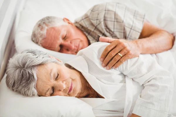 Senior paar slapen op bed — Stockfoto