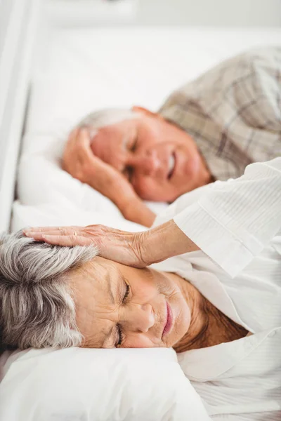 Frau verdeckt Ohren, während Mann schnarcht — Stockfoto