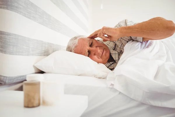 Gefrustreerd senior man in bed liggen — Stockfoto