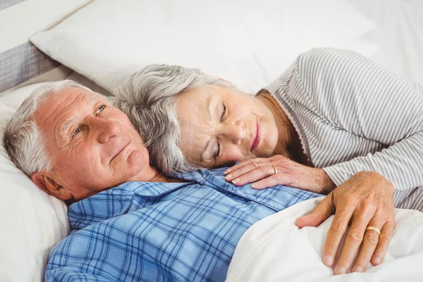 Man lying awake next to asleep woman — Stock Photo, Image