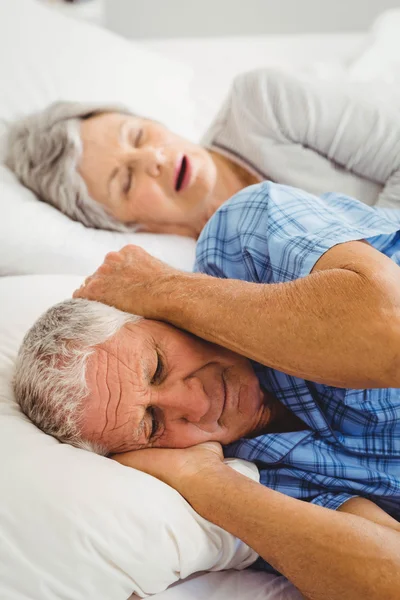 Mann verdeckt Ohren Frau schnarcht — Stockfoto