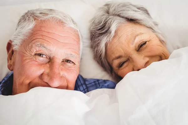 Heureux couple de personnes âgées souriant au lit — Photo