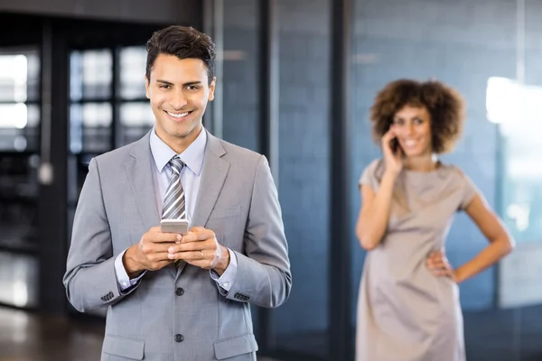 Businessman using phone in office — Stock Photo, Image